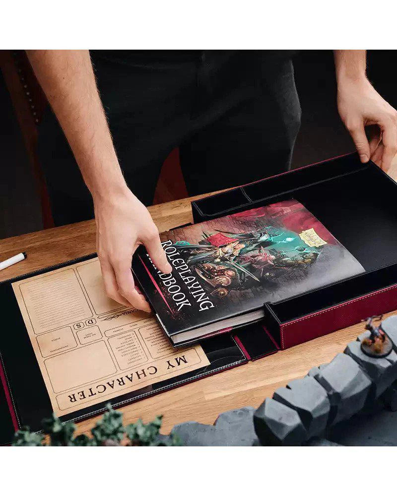 Dragon Shield RPG: Player Companion - Blood Red being placed in a game box with sheets, miniatures, and dice tray.