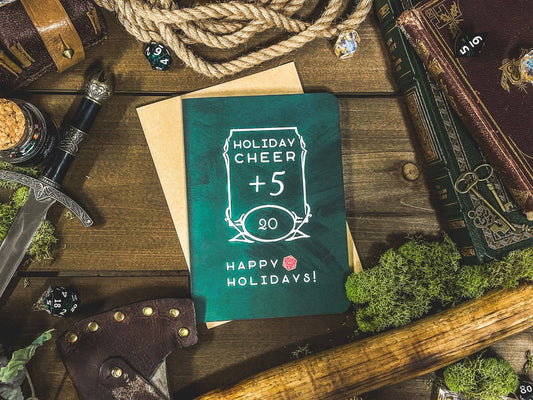 D&D Holiday Cheer +5 Card featuring 20, Happy Holidays text with fantasy items on a wooden table.