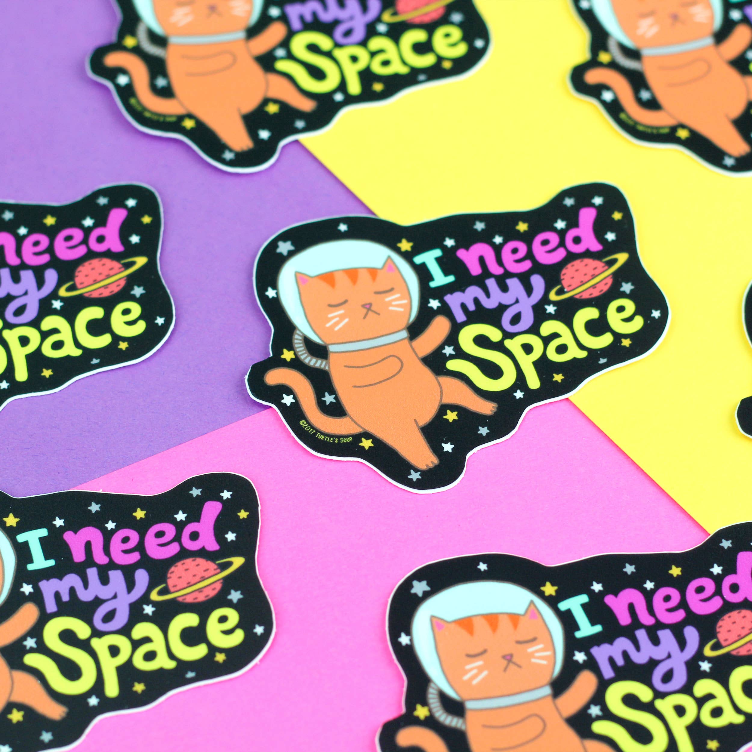 I Need My Space Galaxy Cat eco-friendly vinyl sticker with orange cat in spacesuit on vibrant backgrounds.