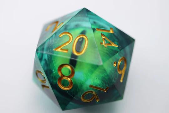 35mm green Cyclops Eye D20 with moving eye and gold numbers, 20 facing up, on a white background.