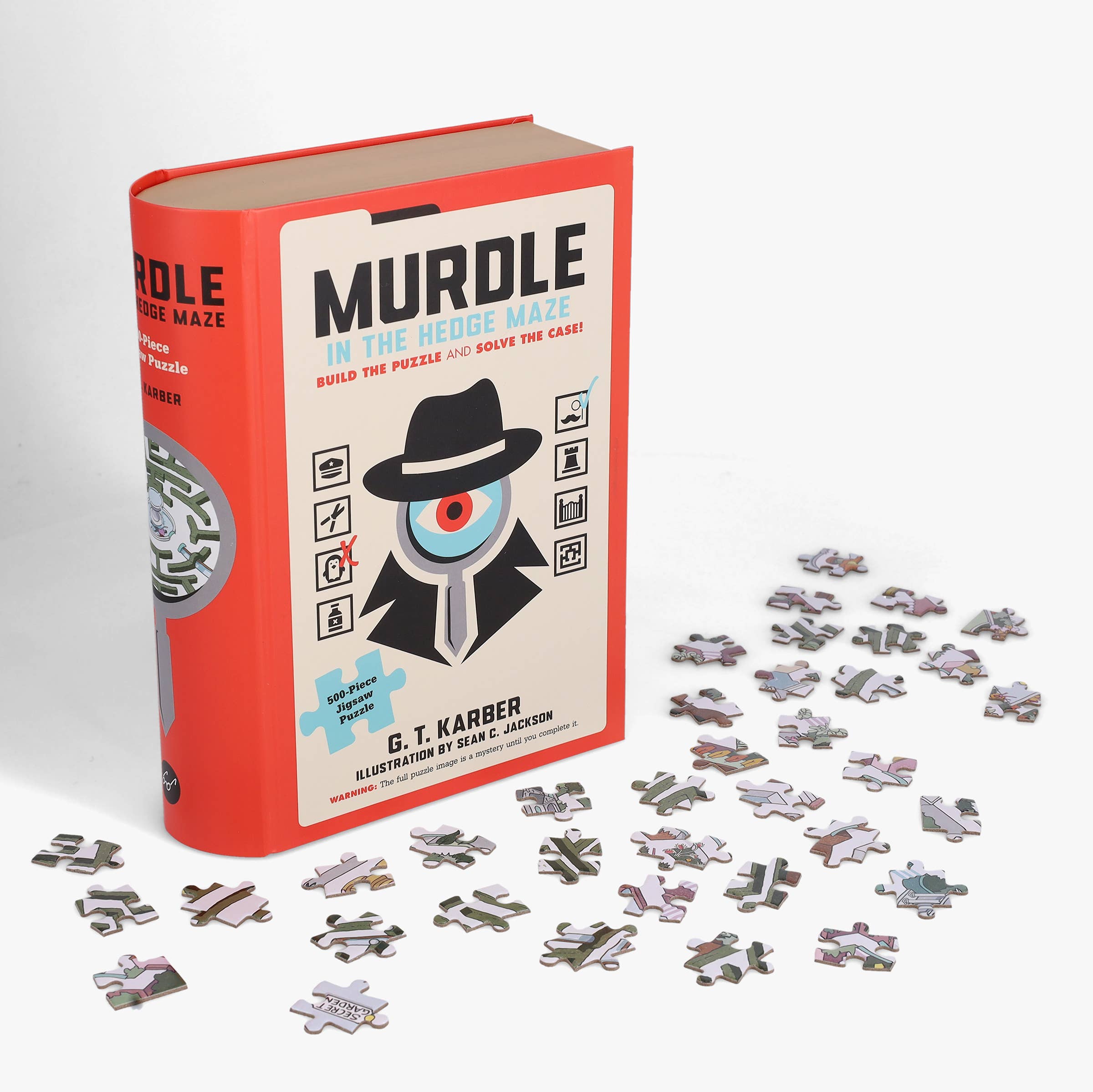 Murdle in the Hedge Maze 500-piece jigsaw puzzle next to its book with pieces scattered on a white background.