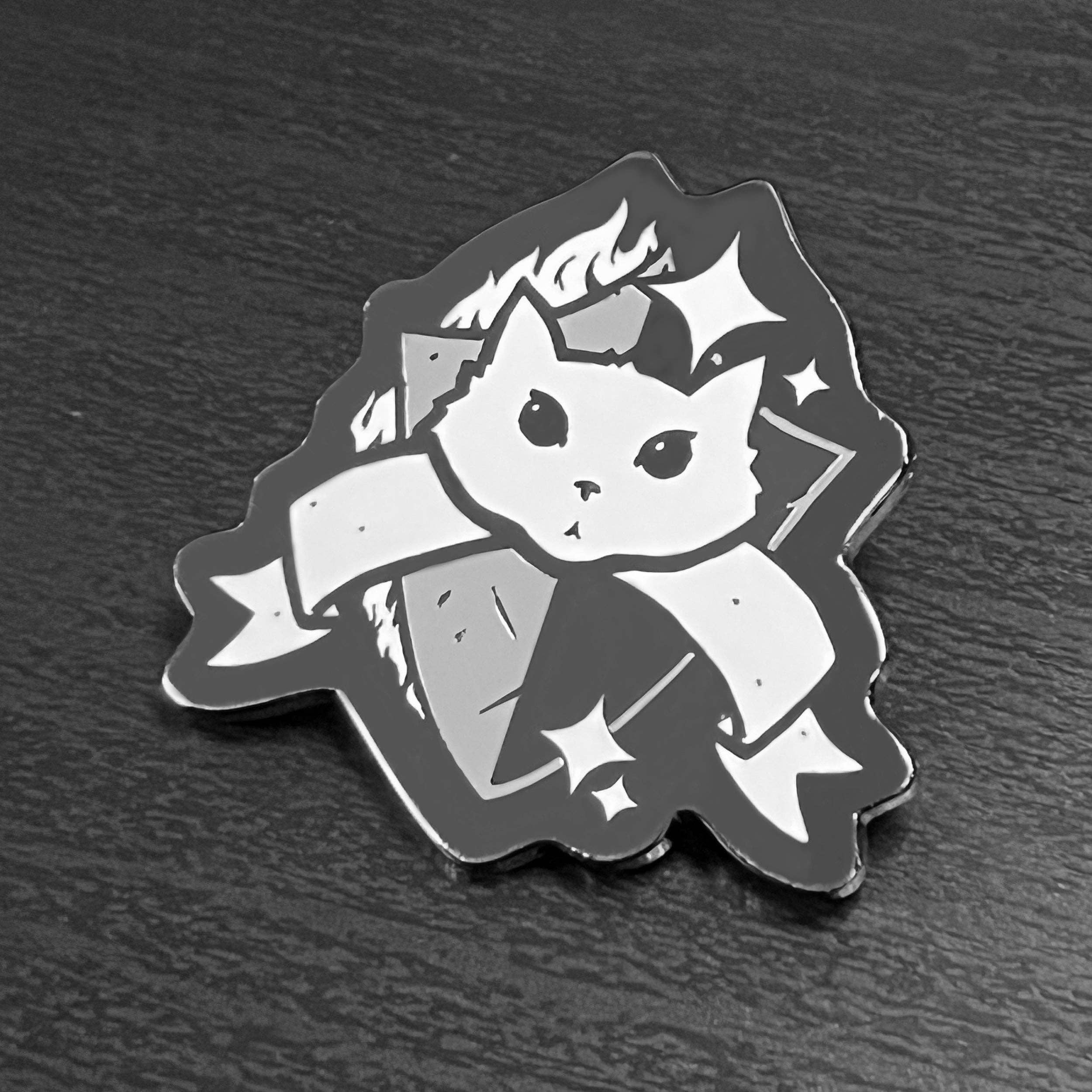 Paladin enamel pin featuring a black and white cat face with ribbon, shield, stars, and flame.