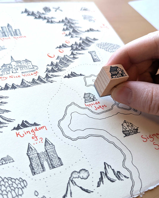Castle Pack Map Making Stamp Kit used to stamp a small house onto a map.