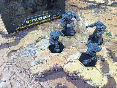 Four Battletech miniatures on a hex map with the Inner Sphere Urban Lance Force Pack visible in the background.