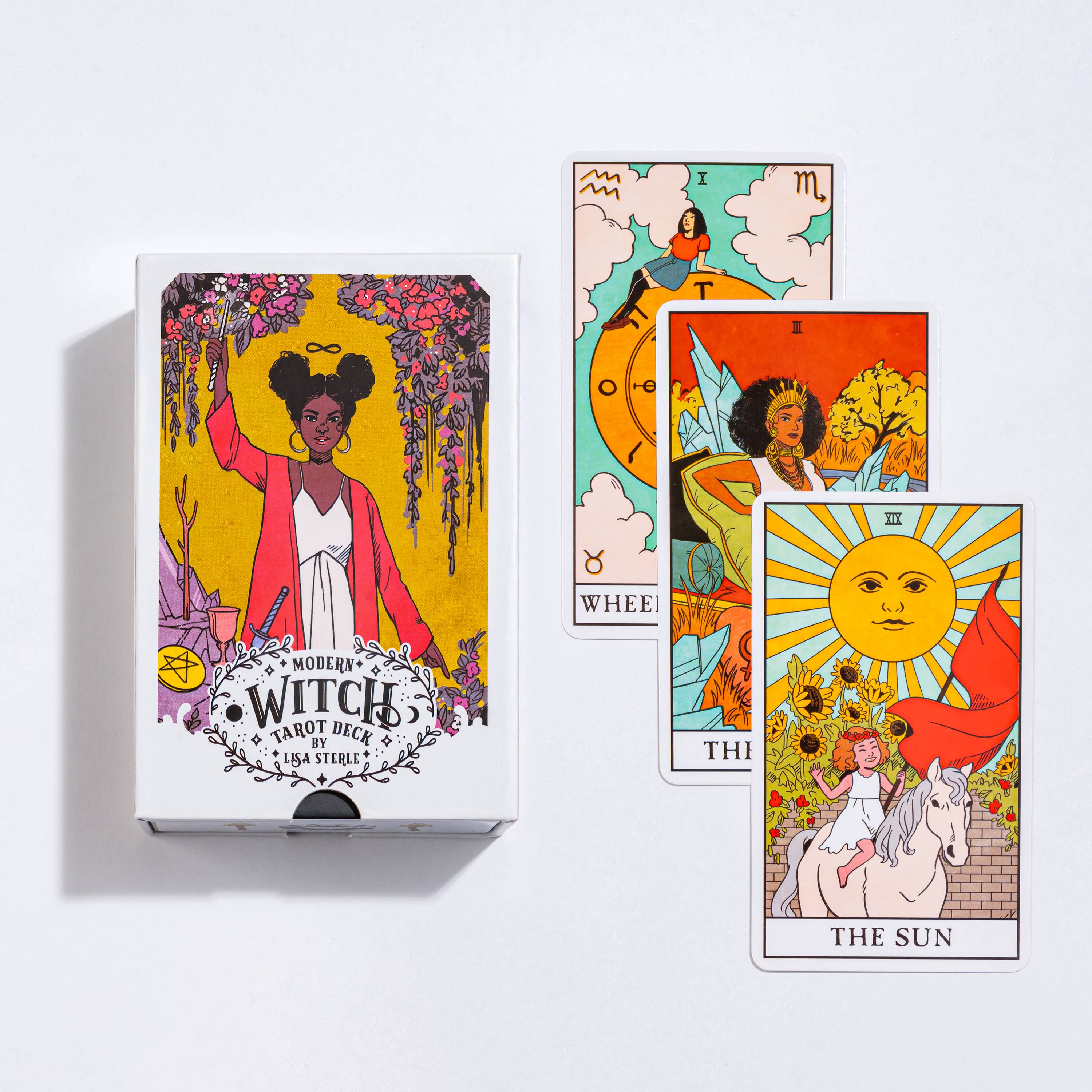 Modern Witch Tarot Deck with The Wheel of Fortune, The High Priestess, and The Sun cards displayed.