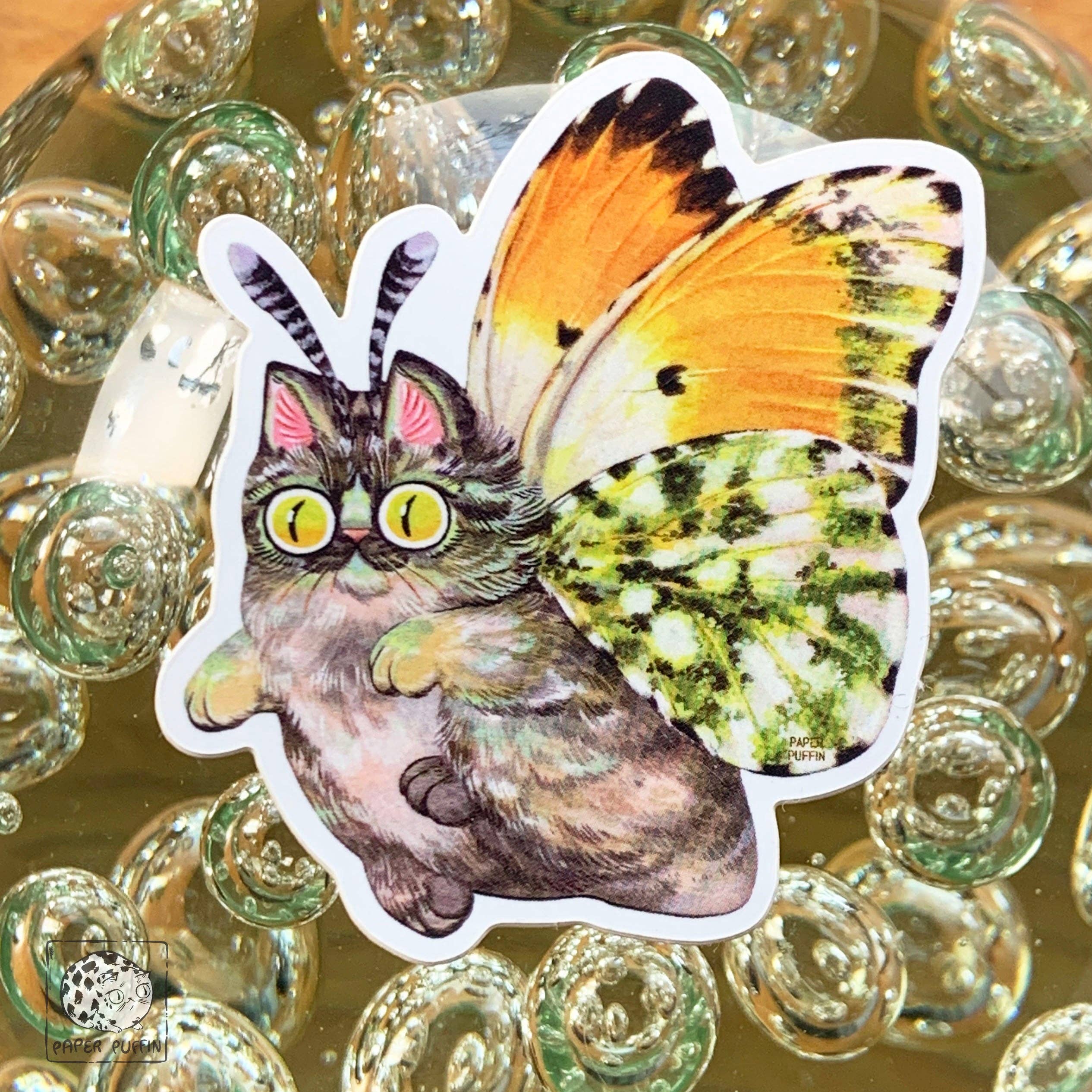 Moth Cat Tippy die-cut sticker featuring a fluffy cat with butterfly wings and antennae.