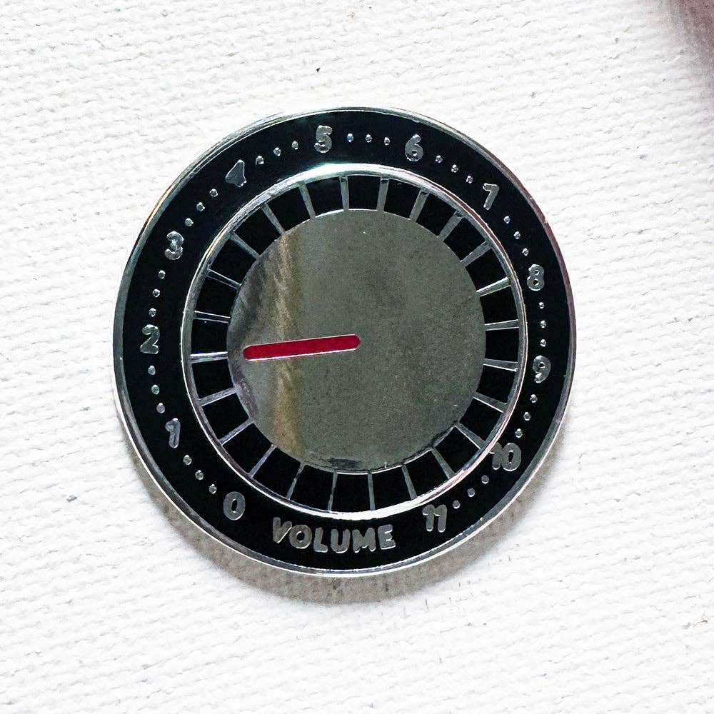 Amp Knob Deluxe pin: a circular silver-plated hard enamel pin shaped like a volume knob labeled 0 to 11 with a red indicator.