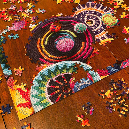 Limited edition Buena Onda Games puzzle with a circular, mandala-like design, shown partially assembled.