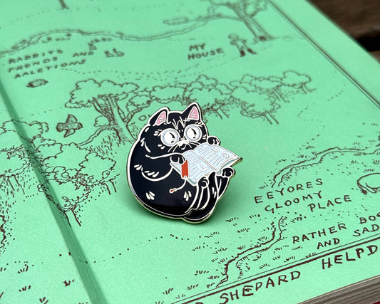 Book Reader Cat enamel pin featuring a black cat reading a book.