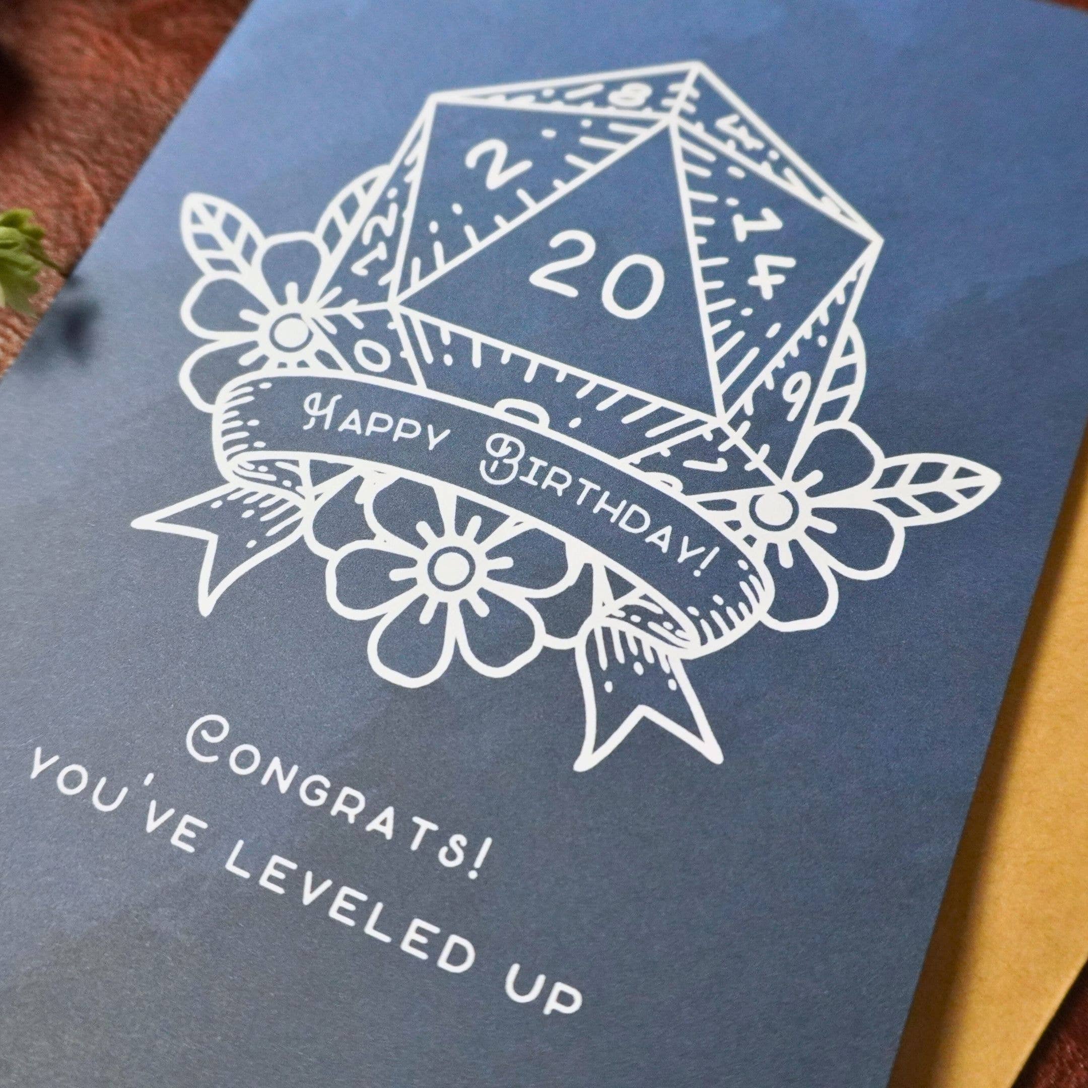 D20 Leveled Up DnD Birthday Card, blue with white D20, Happy Birthday banner, and leveled up message.