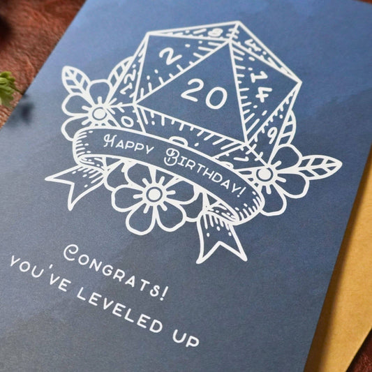 D20 Leveled Up DnD Birthday Card, blue with white D20, Happy Birthday banner, and leveled up message.