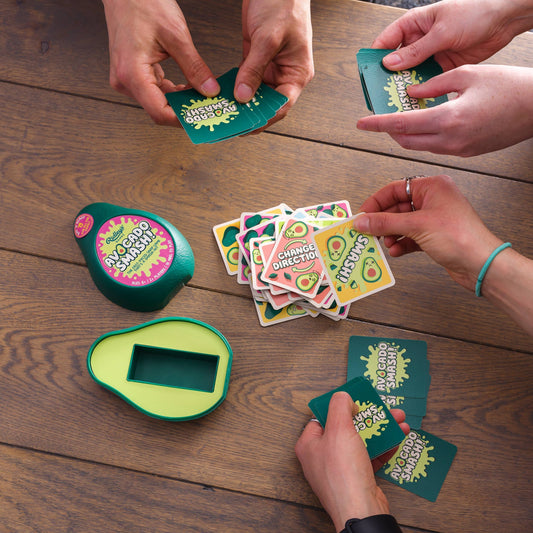 Avocado Smash card game with avocado cards and green avocado-shaped holder on a table with four players.
