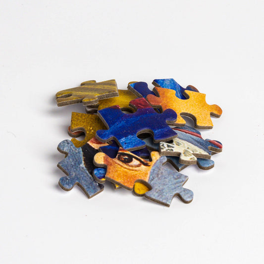 Frida Kahlo – Two Fridas puzzle pieces arranged in a small pile on a white background.