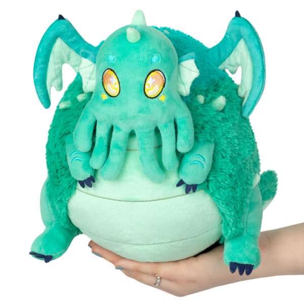 Turquoise Mini Baby Cthulhu II plush with embroidered yellow eyes, wings, and facial tentacles held in a hand.