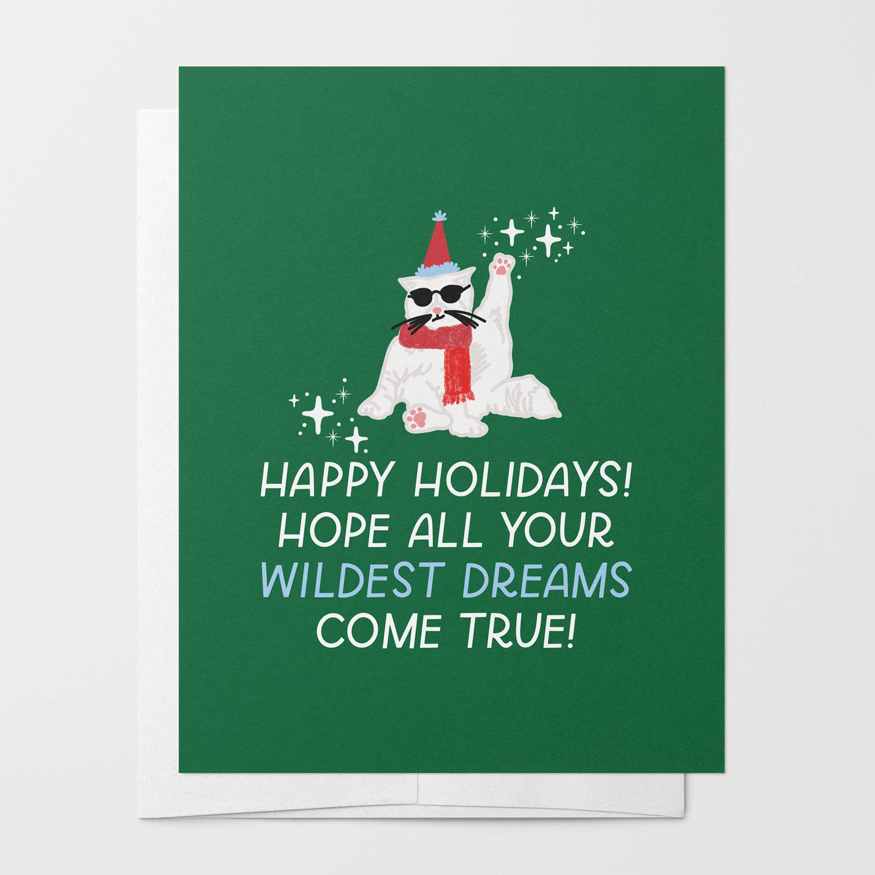 Wildest Dreams Holiday Card with a white cat wearing sunglasses, a red scarf, and a party hat; text: Happy holidays.