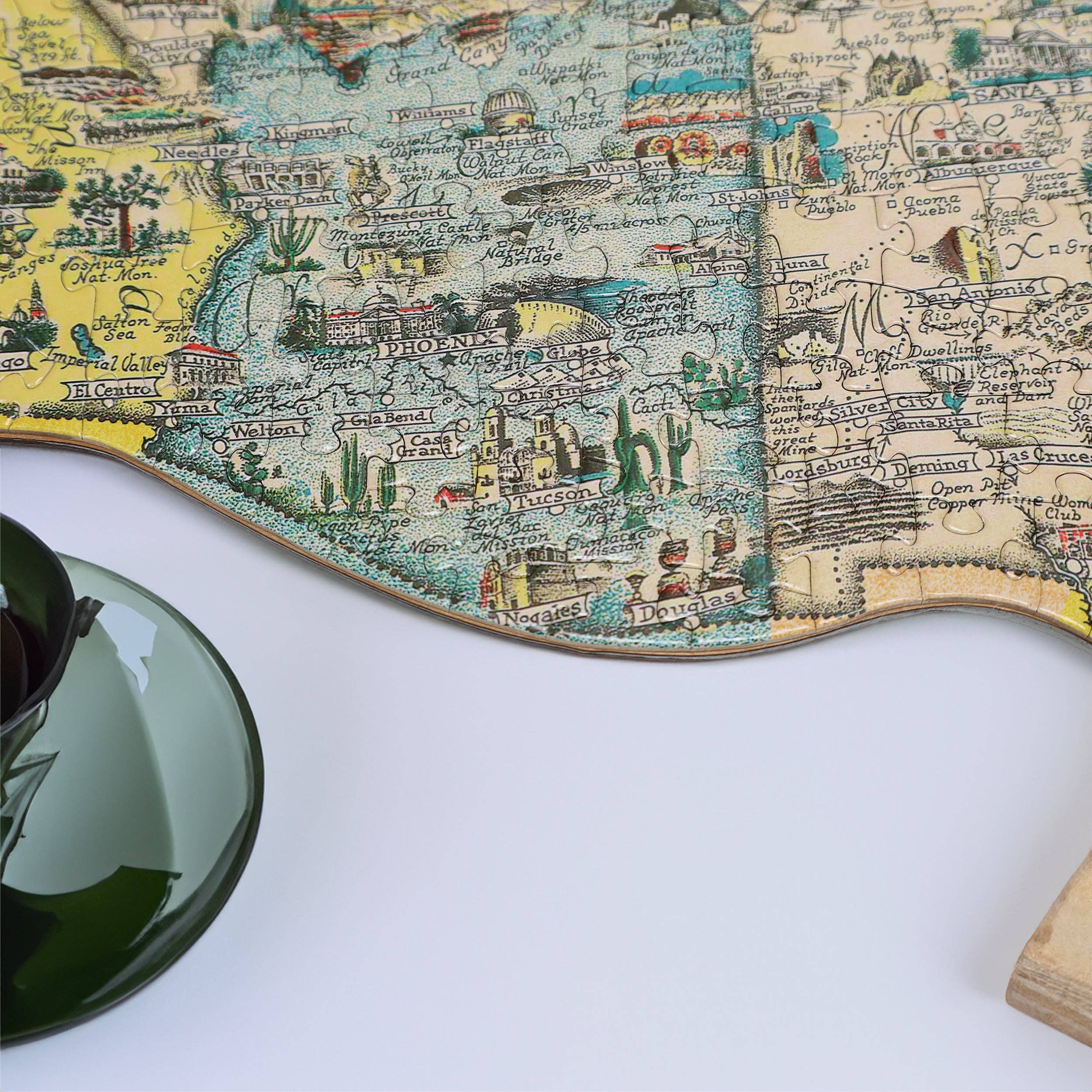 America the Wonderland Jigsaw Puzzle (1,000 pieces) with green cup and saucer on white surface.