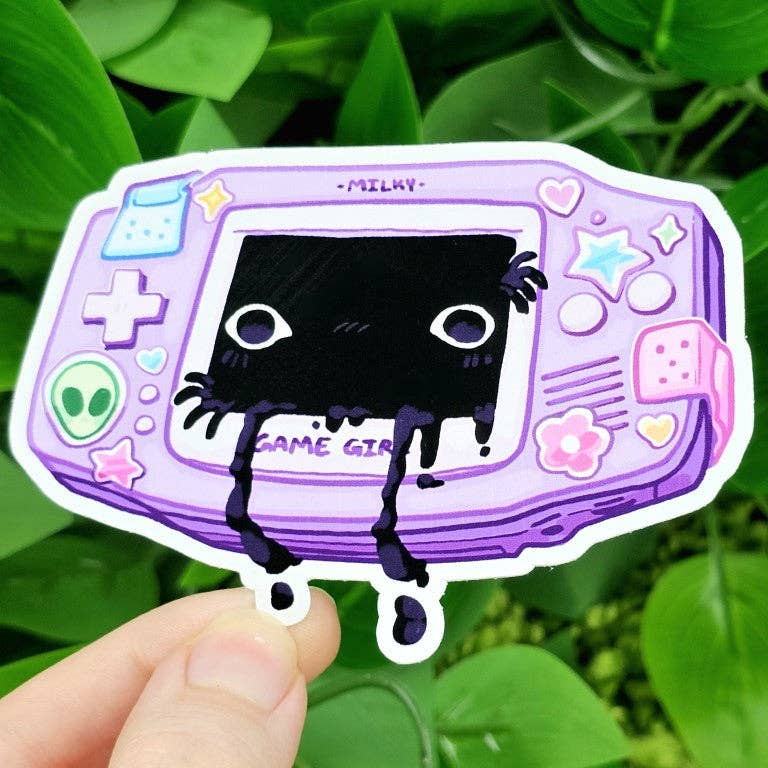 Creepy Game Console Sticker showing a purple handheld console with a black, gooey creature on the screen, held in a hand.