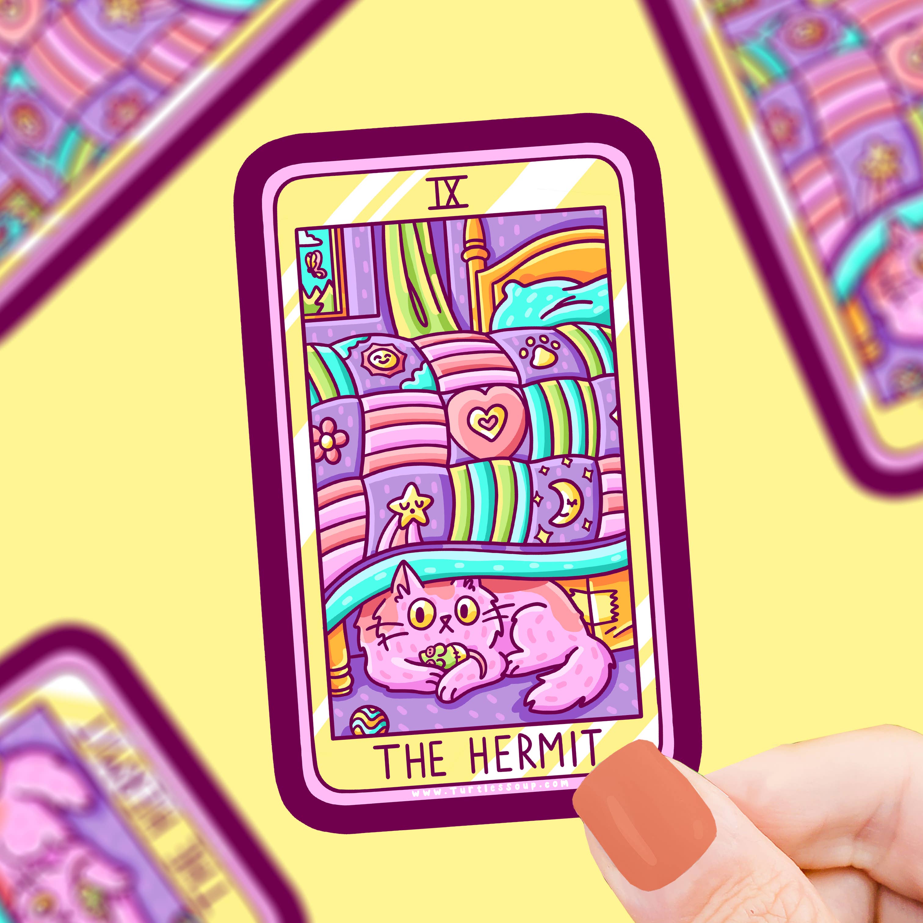 The Hermit Cat Major Arcana Tarot Card Vinyl Sticker with a pink cat on a bed, held in a hand.