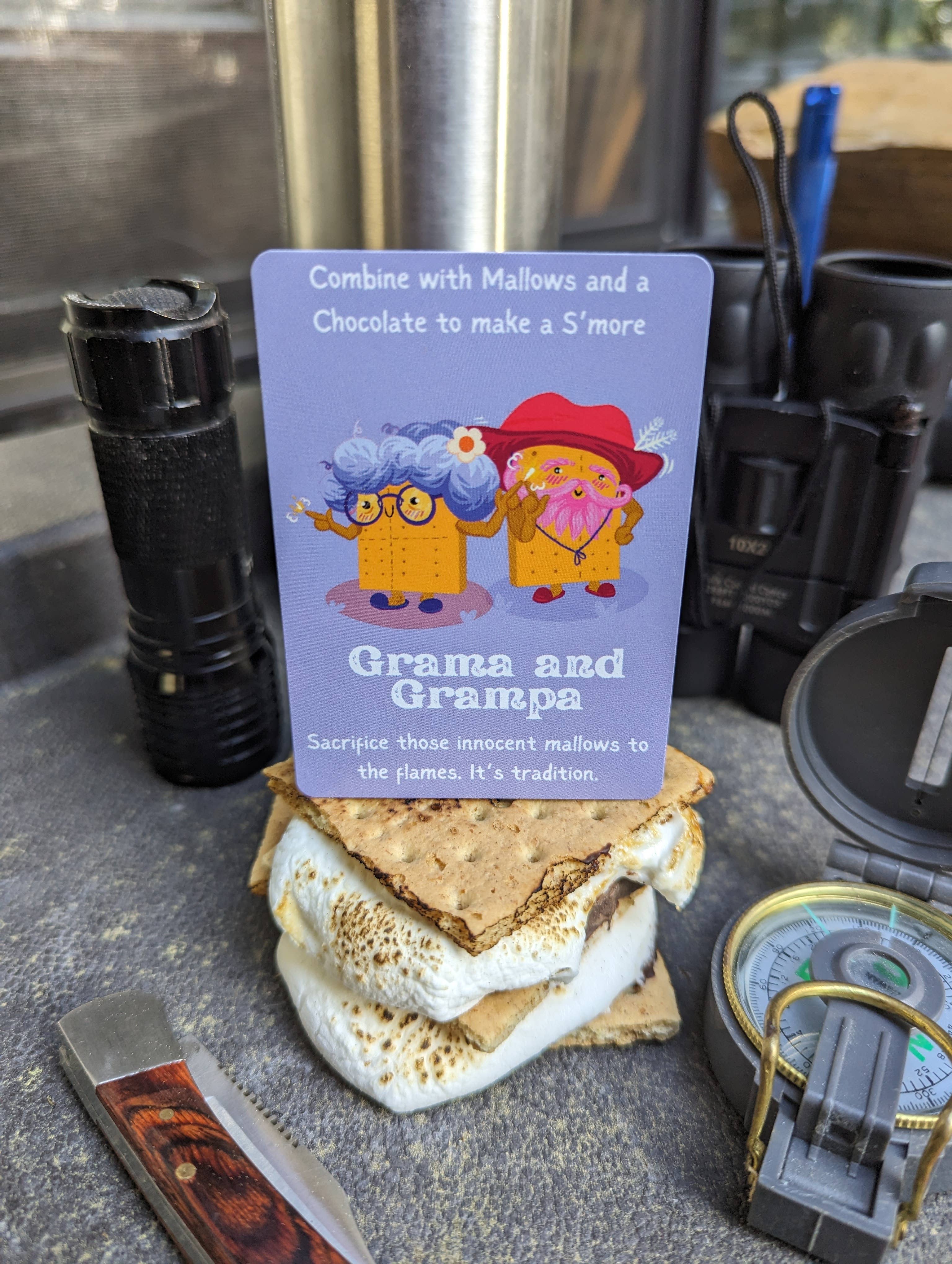 Roast board game with Grama, Grampa, gooey treats, camping tools, and compass as components.