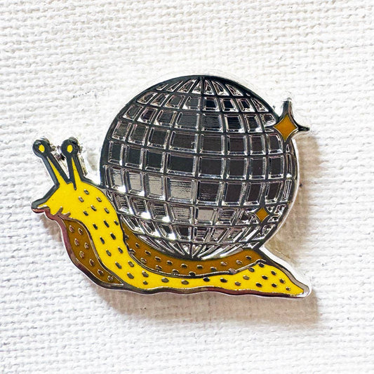 Disco Snail pin: 1.25-inch yellow hard enamel snail with a metallic silver disco ball shell.
