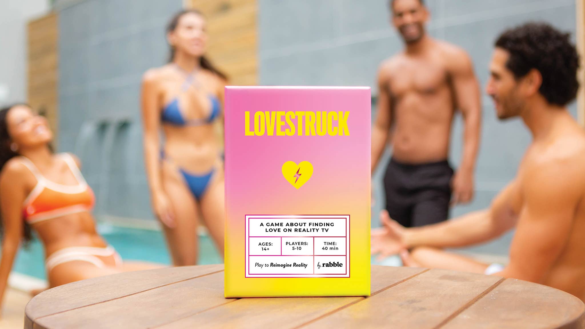 Lovestruck board game box by a pool, with four people in swimsuits nearby.