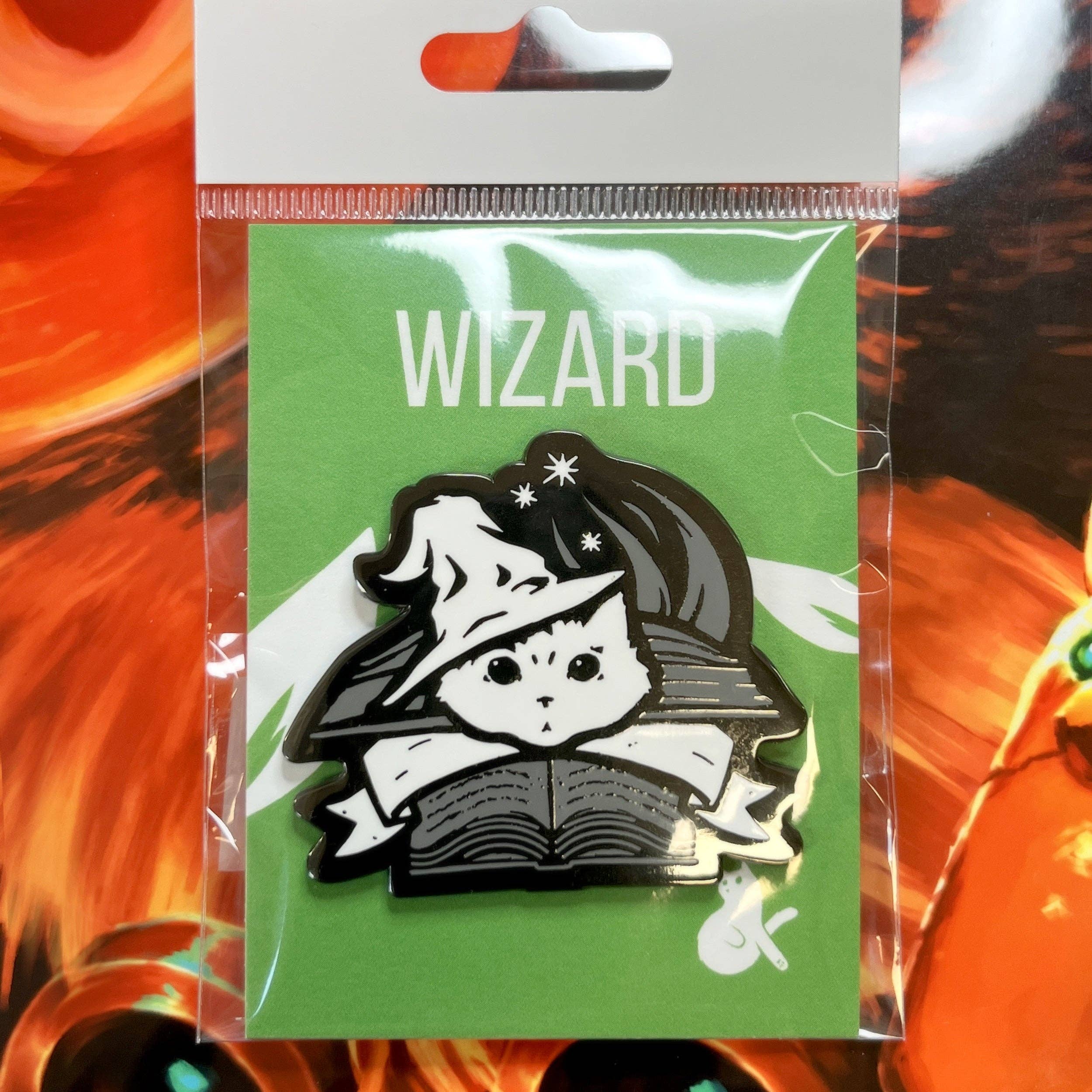 Hard enamel pin of a cat in a wizard hat reading, on green “WIZARD” card, with black nickel plating.