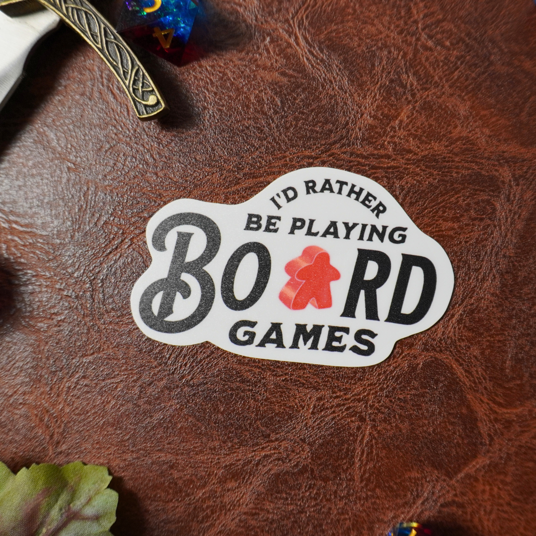 “Id Rather Be Playing Board Games” sticker, with a red meeple as the “A” in board.