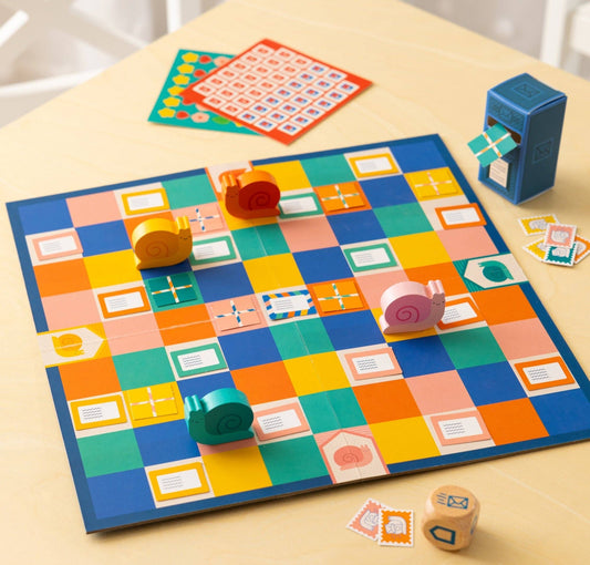 Snail Express board game with snails, dice, cards, tokens, and blue mailbox displayed on a wooden table.