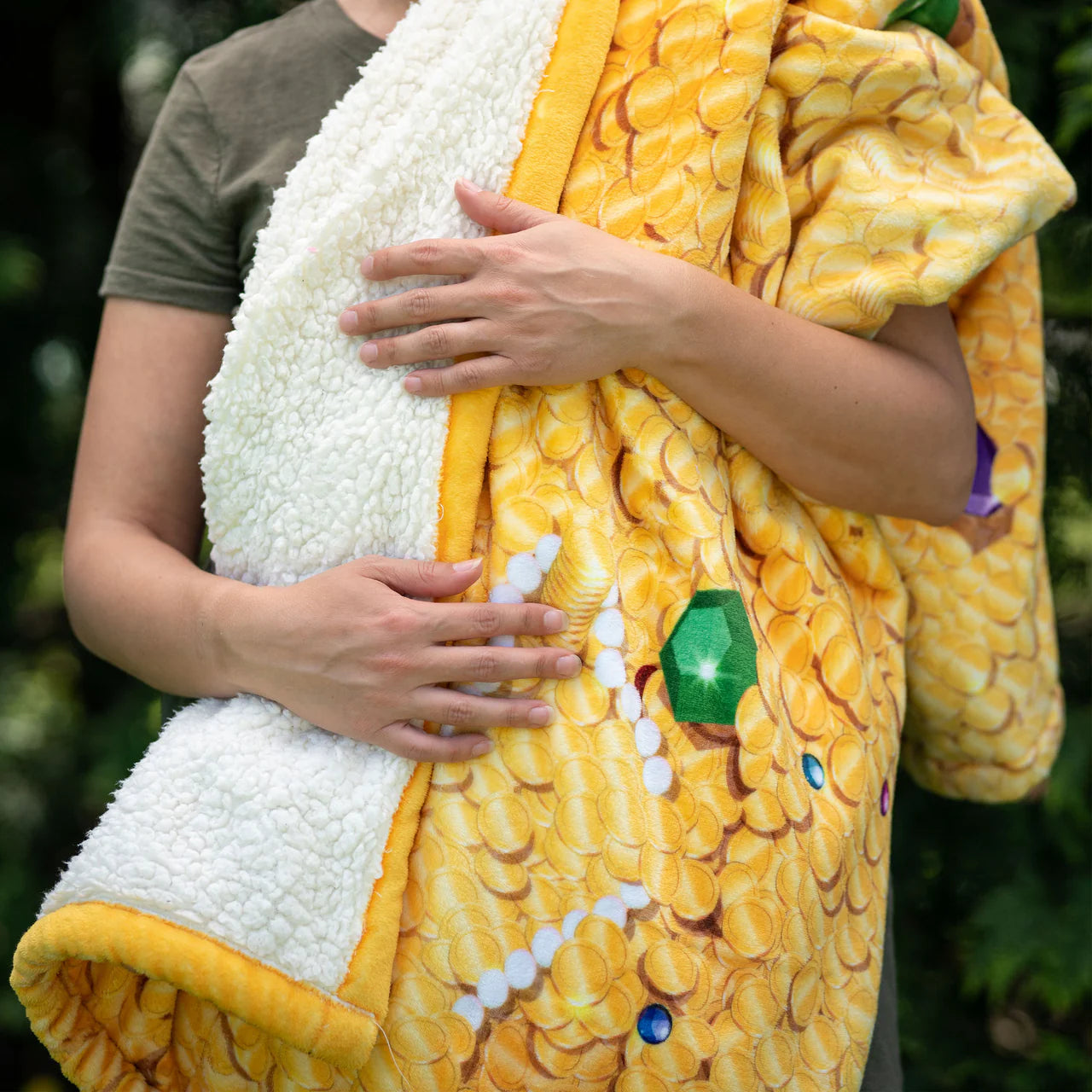 Treasure Hoard Blanket by Tentacle Kitty with white fleece lining held outdoors.