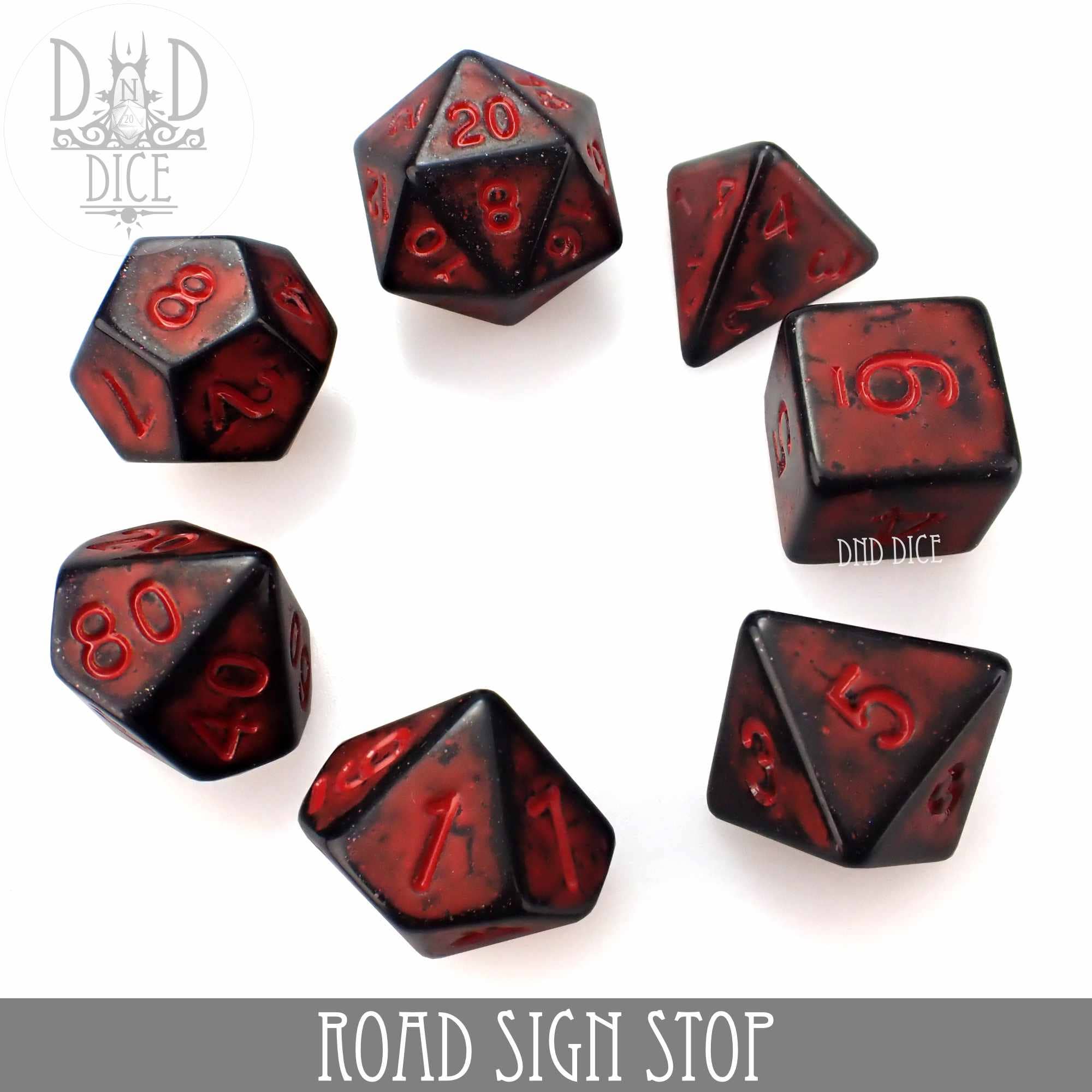 Seven black-and-red Road Sign Stop acrylic dice on a white background.