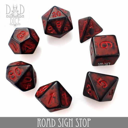 Seven black-and-red Road Sign Stop acrylic dice on a white background.