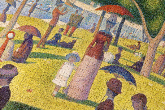 Puzzle featuring Georges Seurats Sunday Afternoon, depicting people relaxing in a park inspired by La Grande Jatte.