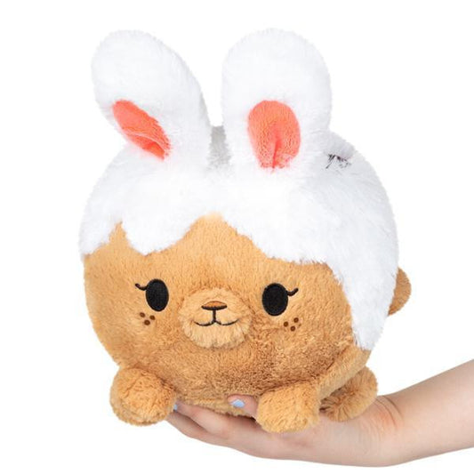 Mini Squishable Cinnabunny plush with white bunny ears and cinnamon roll details held in a hand.