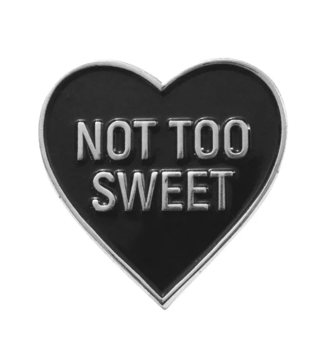 Polished silver heart-shaped pin with bold NOT TOO SWEET lettering.