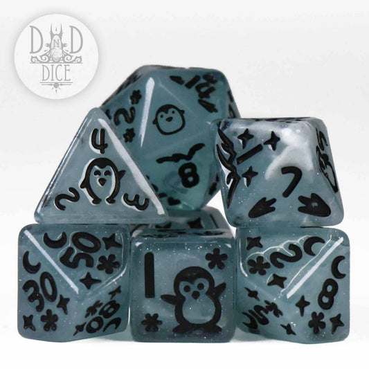 7-piece blue translucent resin dice set with black numbers and penguin illustrations for tabletop gaming.