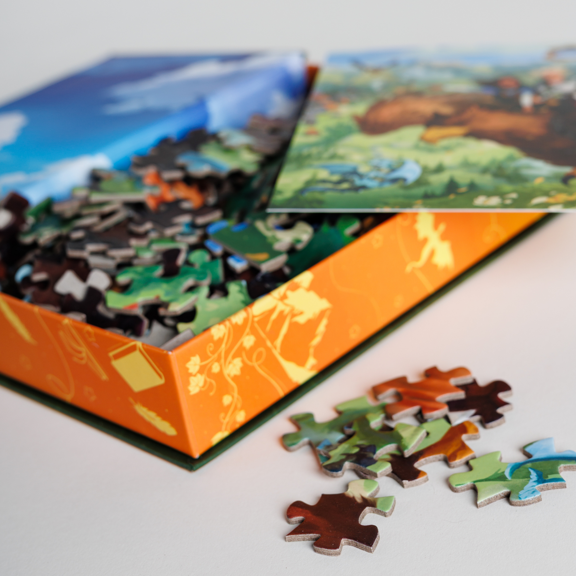Tea You in the Skies Keepsake Puzzle by Tomes & Tea, opened with colorful pieces on a white surface.