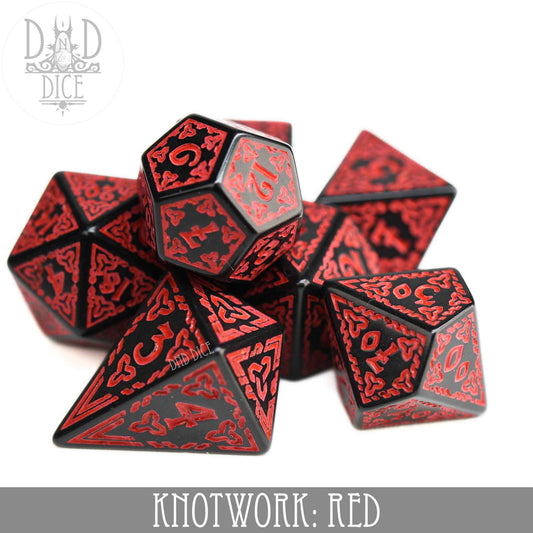 Red and black acrylic dice set with red knotwork designs, including a teardrop-shaped D4.