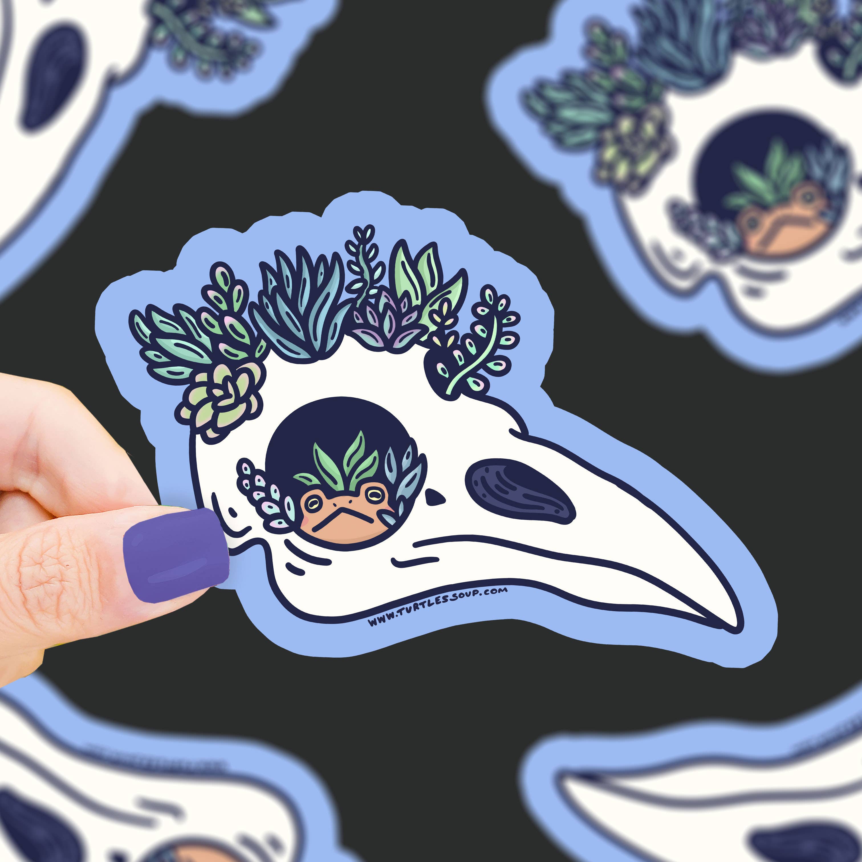Raven Skull Succulent Garden Vinyl Sticker held in a hand; additional similar stickers shown in the background.