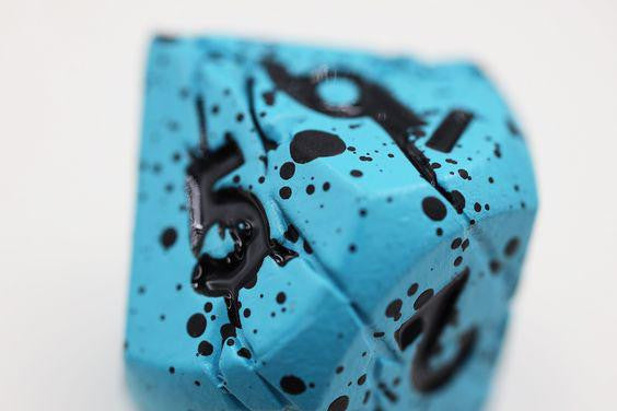 Blue Quarry Metal RPG die with black numbers and speckled patterns.