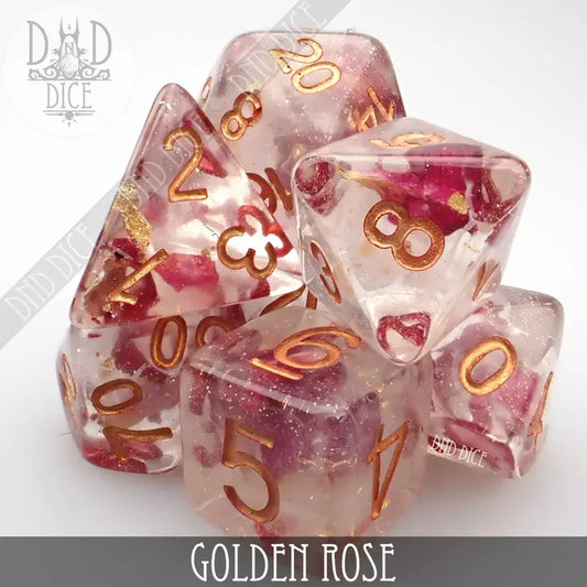 Golden Rose 7-piece clear resin polyhedral dice set with gold numbers and pink flower petals inside.