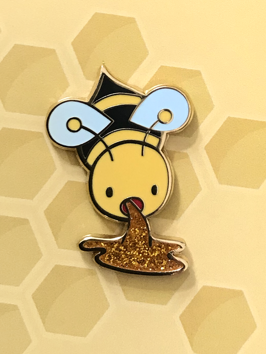 Bee Barf Enamel Pin showing a gold-plated bee with sparkling honey on a honeycomb-patterned background.