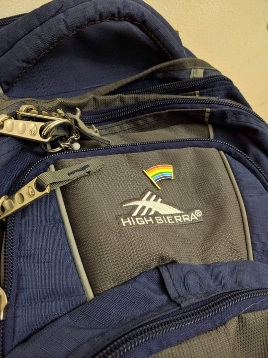 High Sierra backpack with a Pride Flag pin on the front pocket.