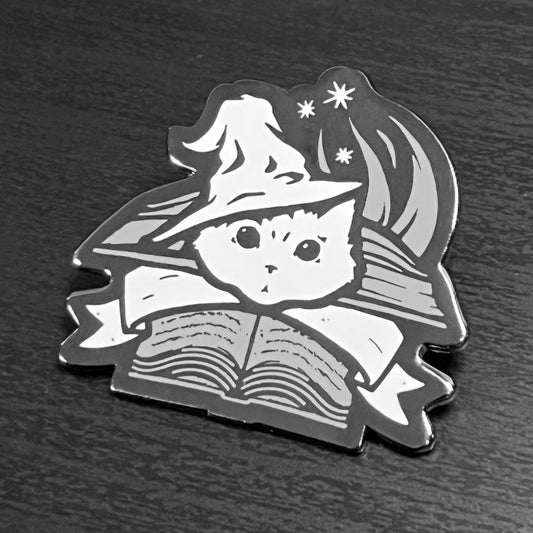 Wizard Enamel Pin featuring a cat in a wizard hat with stars and an open book.