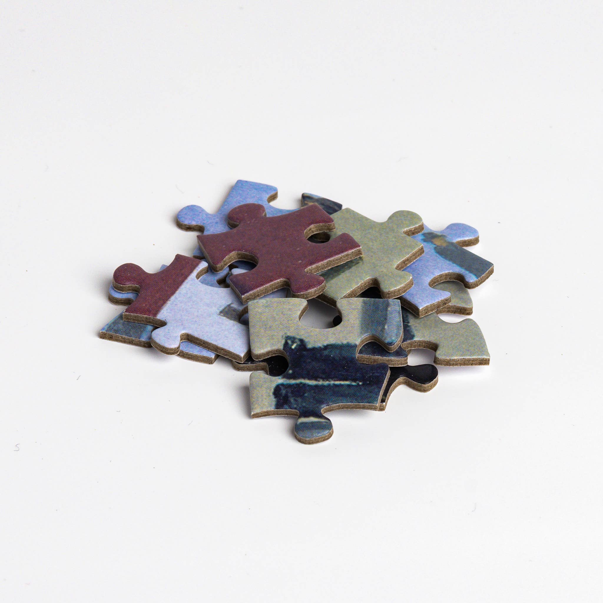 Puzzle - René Magritte - Golconda pieces in a small pile on a white background.
