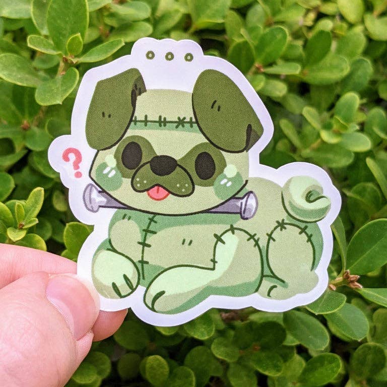 Halloween Puppies Stickers featuring a green Frankenstein pug with neck bolts held in a hand.