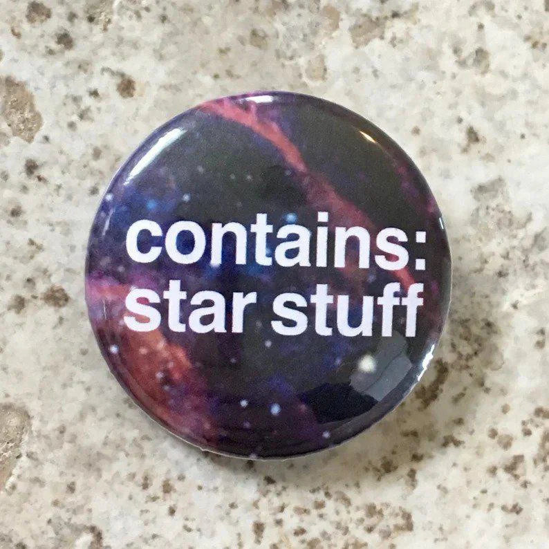 Contains Star Stuff button pin, 1.25, features a galaxy design and white text reading contains: star stuff.
