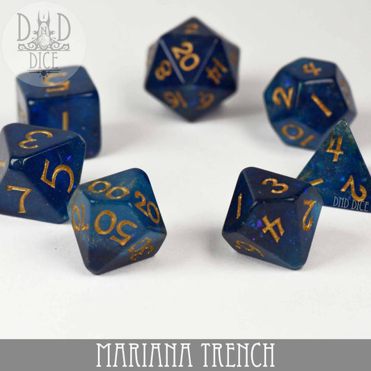 Mariana Trench 7-piece dark blue glitter resin dice set with gold numbering.