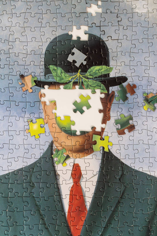 1000-piece puzzle featuring René Magrittes Son of Man, with a suited man in a bowler hat and an apple.