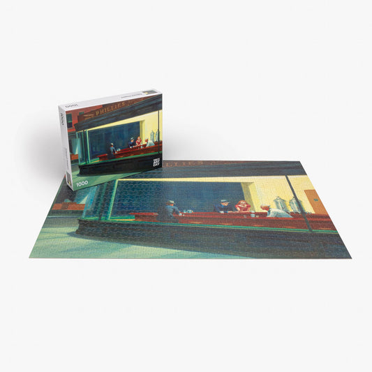 Edward Hopper Nighthawks 1000-piece jigsaw puzzle completed, shown with its box on a white surface.