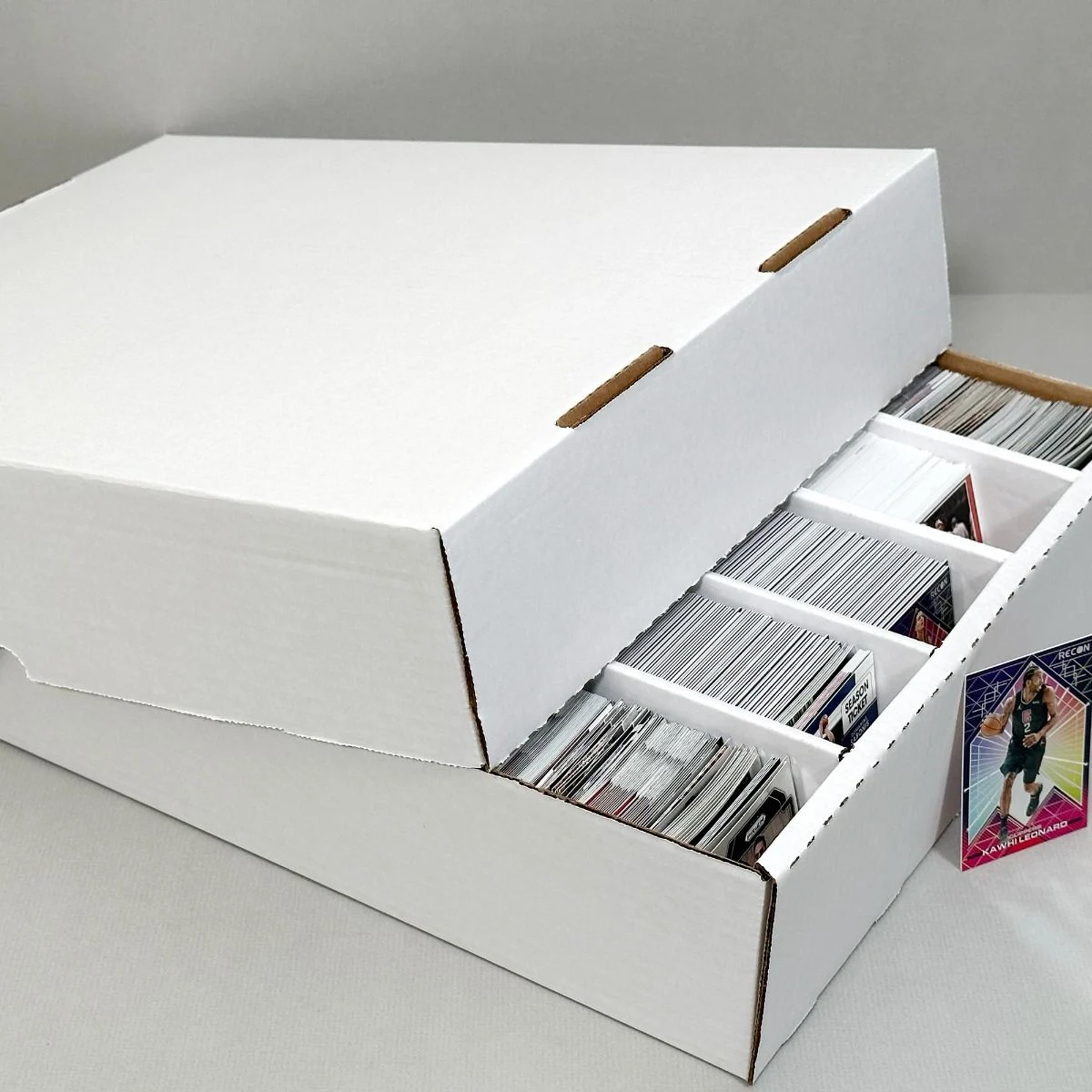 5000 count storage box with dividers holding trading cards, one card partially pulled out.